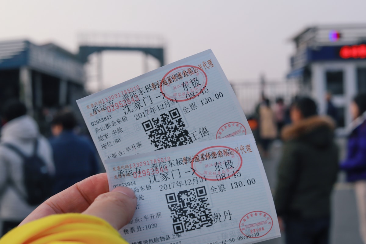 Manos sosteniendo dos boletos de entrada.